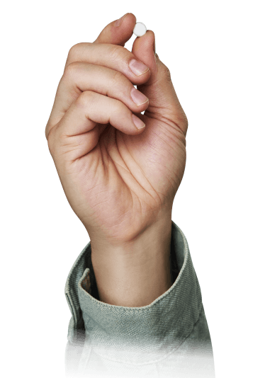 A hand holding a XOCOVA pill